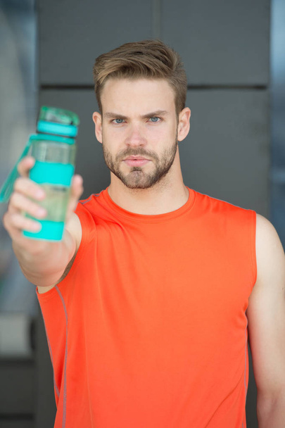 Bearded man share water with you. Presenting product. Thirst and health. Athlete hold plastic bottle. Drink some water. Stay hydrated and healthy after training. Sport and fitness - 写真・画像
