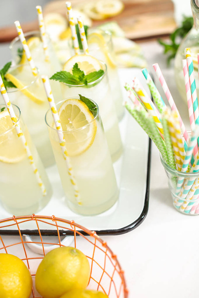 Traditional lemonade with a slice of fresh lemon and mint with paper straw in the glass. - Foto, Imagem