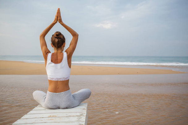 Mulher branca praticando ioga no litoral do oceano trópico
 - Foto, Imagem