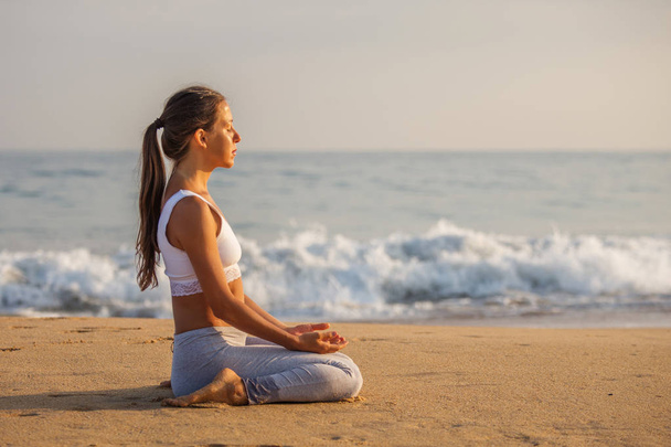 Kaukasische Frau praktiziert Yoga an der Küste des tropischen Ozeans - Foto, Bild