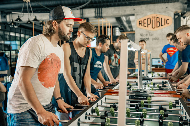 Photo KYIV, UKRAINE, bar league of Grants KickerKicker 10 June 2018. Active men and women have fun during table soccer game. - Foto, afbeelding