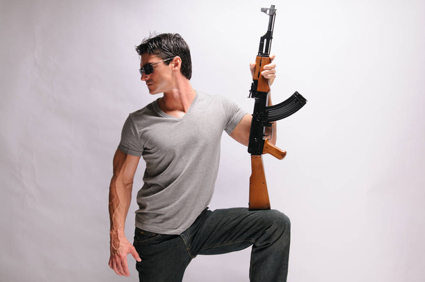 El hombre sexy se aferra a un rifle
 - Foto, Imagen