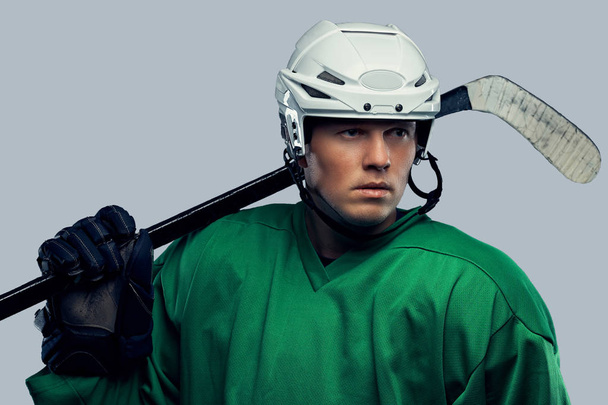 Professional hockey player in full equipment with gaming stick on shoulders. Isolated on a gray background.  - Photo, Image
