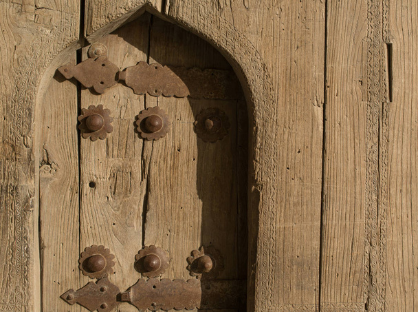 Oude houten deur met metalen klinknagels in Buchara, Centraal-Azië. - Foto, afbeelding