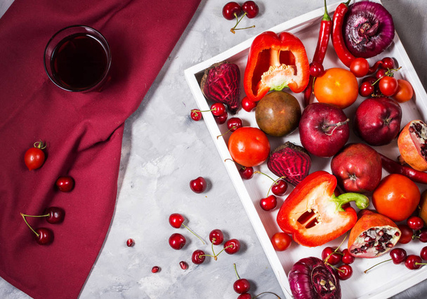 Verduras orgánicas rojas crudas con ingredientes frescos para cocinar saludablemente en bandeja blanca sobre fondo de hormigón, vista superior
 - Foto, imagen