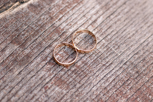 Two golden wedding rings on wood background - 写真・画像