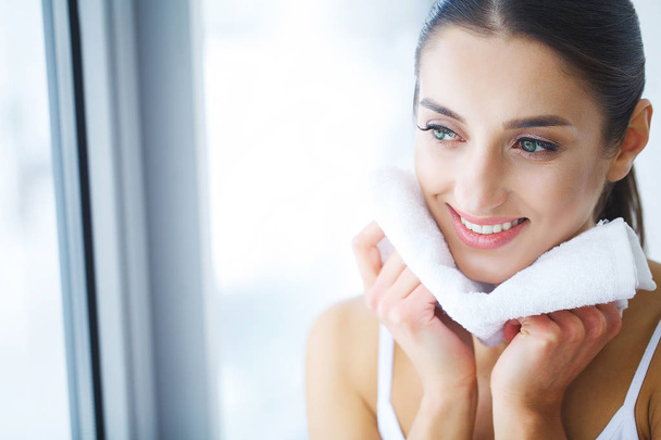 Gesichtswaschen. glückliche Frau trocknet Haut mit Handtuch - Foto, Bild
