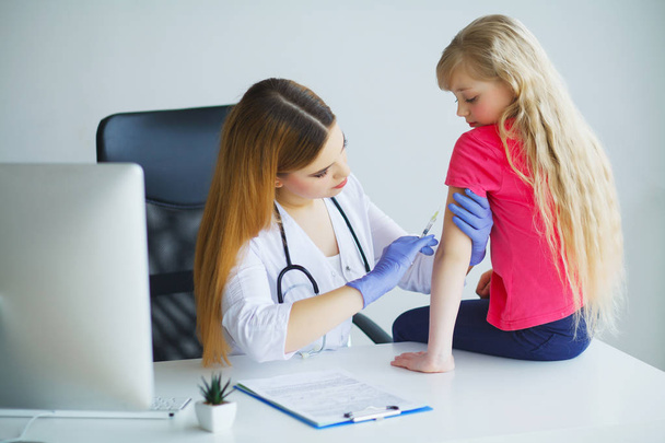 Arzt spritzt Impfung in Arm kleines Mädchen, gesundes und medizinisches Konzept - Foto, Bild