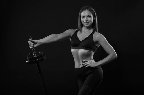 Sport vrouw tillen gewicht op zwarte achtergrond - Foto, afbeelding