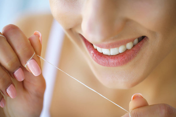 Dental Health. Woman With Beautiful Smile Flossing Healthy Teeth. High Resolution Image - Foto, imagen