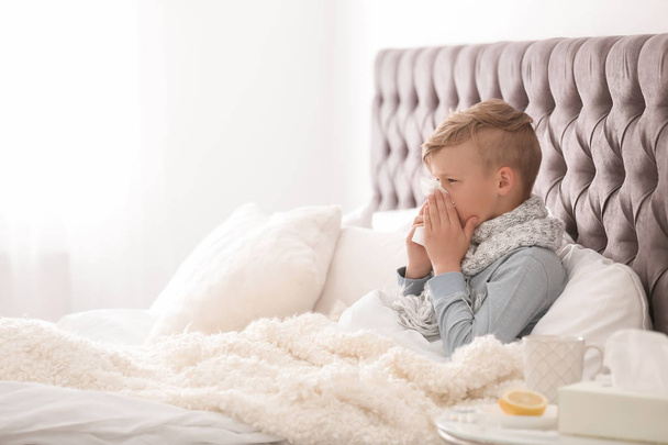 Sick little boy with tissue suffering from cold in bed - Fotografie, Obrázek