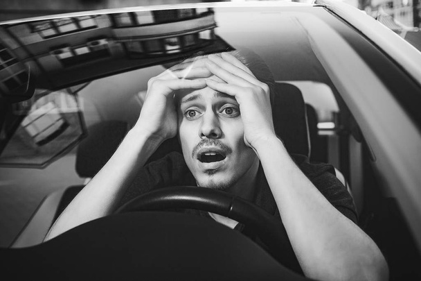 Wypadku. Młody człowiek kaukaski jazda samochodem wstrząśnięty o to żeby wypadku drogowego - Zdjęcie, obraz