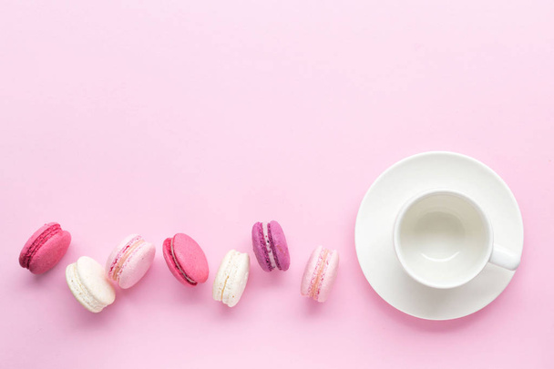 Kleurrijke taart macaron of macaroon geïsoleerd over pastel roze achtergrond. Bovenaanzicht. - Foto, afbeelding