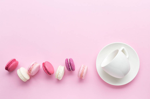 Colorful cake macaron or macaroon isolated over pastel pink background. Top view. - 写真・画像