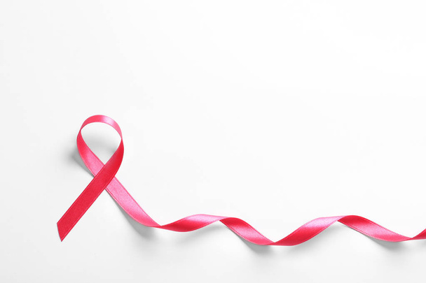 Pink ribbon on white background, top view. Cancer awareness - Fotografie, Obrázek