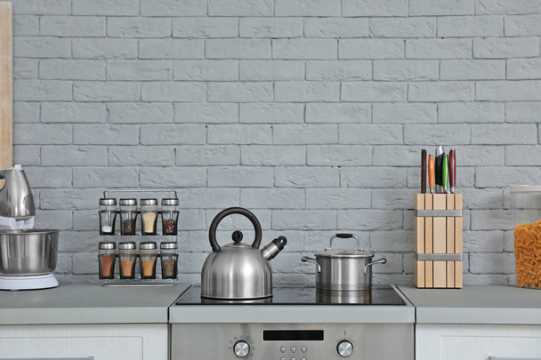 Современный кухонный интерьер с новой мебелью и различной посудой
 - Фото, изображение
