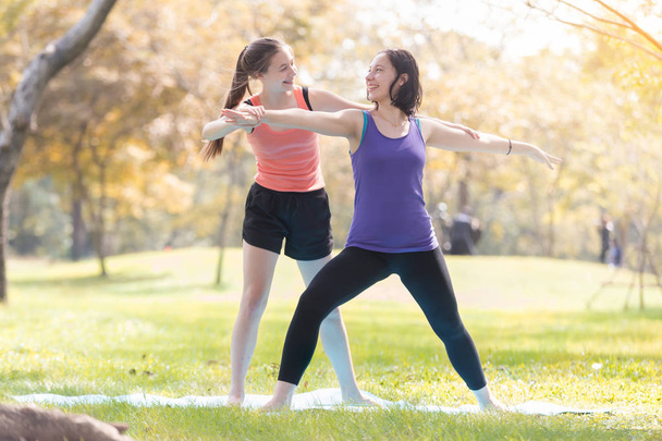 Mujer joven de vacaciones haciendo yoga posan meditación en el parque público Deporte Concepto saludable
. - Foto, Imagen