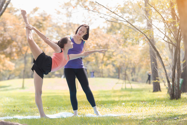 Mujer joven de vacaciones haciendo yoga posan meditación en el parque público Deporte Concepto saludable
. - Foto, imagen