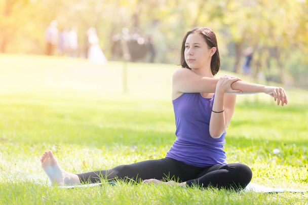 Jonge vrouw vakantie doen yoga pose meditatie in het openbare park Sport gezond concept. - Foto, afbeelding