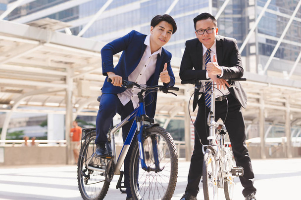 Asiatique beau jeune homme d'affaires parler tout en faisant du vélo en ville
 - Photo, image