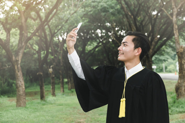éducation, concept de graduation - Hommes de robes de célibataire heureux en plein air dans la nature
 - Photo, image