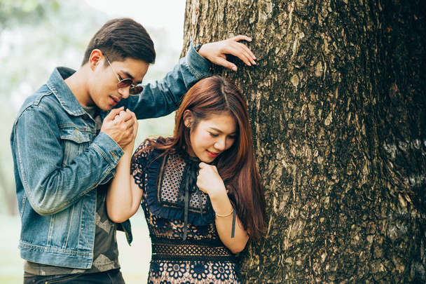 Retrato asiático pareja amar bajo árbol en parque
 - Foto, imagen