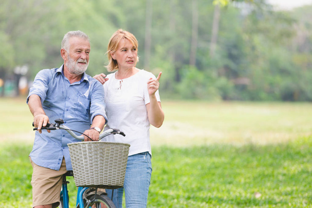 Старша пара щасливо розмовляє на велосипеді
. - Фото, зображення