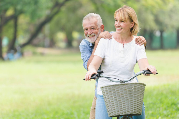 Senior paar lopen hun fiets langs gelukkig praten gelukkig. - Foto, afbeelding