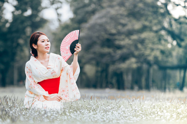 Aasialainen nuori tyttö yllään kimono luonnon vihreä ruoho
. - Valokuva, kuva