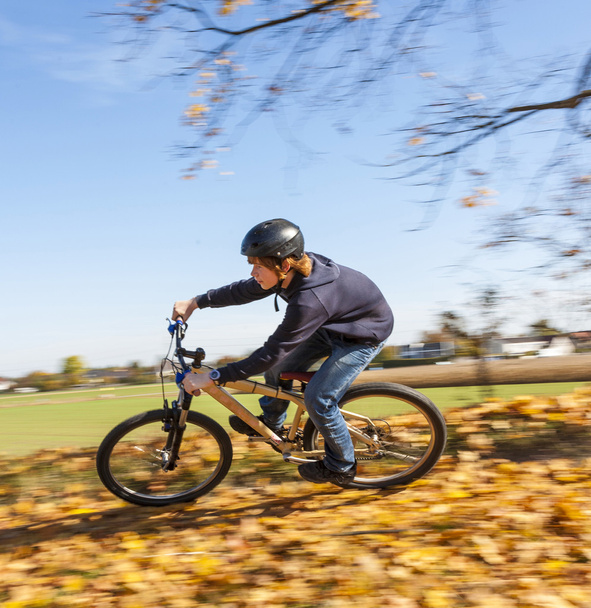 chico salta monta su bicicleta con velocidad en zona abierta y disfruta de r
 - Foto, imagen