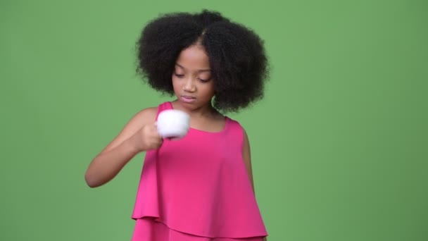 Young cute African girl with Afro hair holding empty coffee cup upside down - Séquence, vidéo