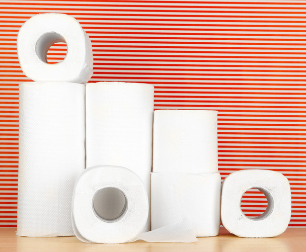 Rolls of toilet paper on striped red background - Фото, изображение