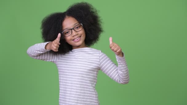 Young cute African girl with Afro hair giving thumbs up - Filmmaterial, Video