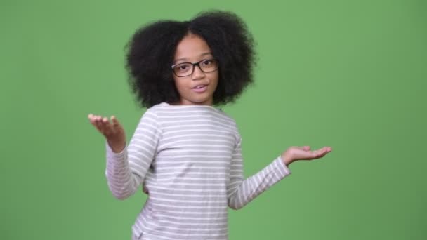 Young cute African girl with Afro hair talking to camera - Séquence, vidéo