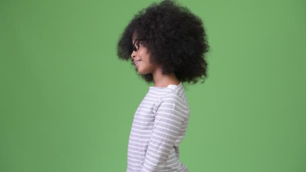 Profile view of young cute African girl with Afro hair smiling - Imágenes, Vídeo