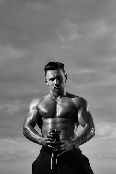 sports nutrition. Wet muscular man with water bottle - Photo, image