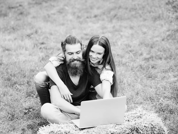 cheerful students. girl or happy woman and bearded man using laptop on nature - Foto, Bild