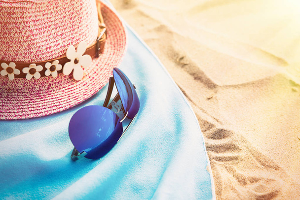 帽子と眼鏡と青いタオルで砂浜。空間と目に見える砂のテクスチャにコピーします。選択と集中. - 写真・画像