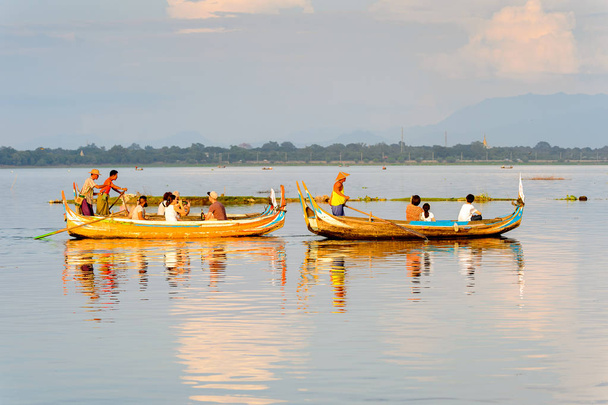 TAUNGTHAMAN LAKE, MYANMAR - AUG 25, 2016: Unidentified Burmese man sails a boat with tourists over the Taungthaman Lake near Amarapura, the former capital of Myanmar - Φωτογραφία, εικόνα