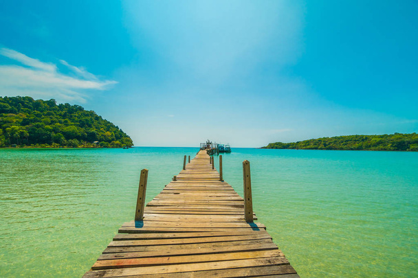 Muelle de madera o puente con playa tropical y mar en la isla paradisíaca para vacaciones de viaje
 - Foto, Imagen