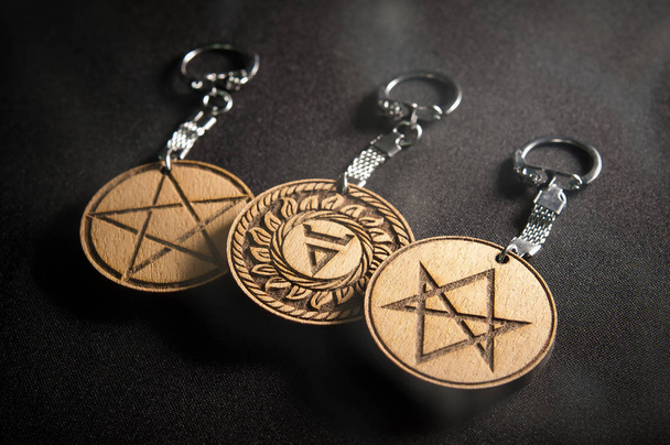 Amuleti in legno con gancio in metallo su un backgroun nero
 - Foto, immagini