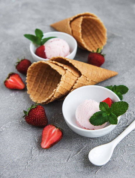 Strawberry ice cream and waffle cone on a stone background - Фото, зображення