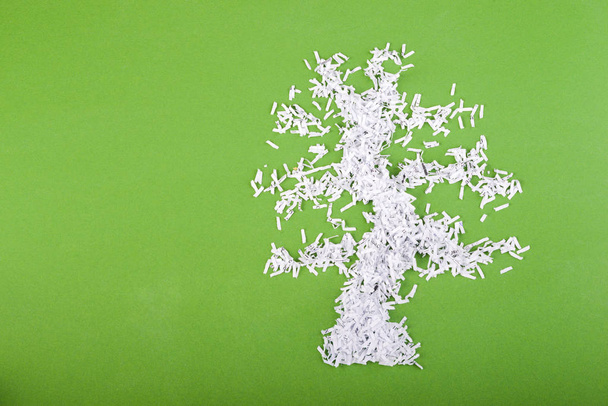 semplice simbolo albero verde composto da particelle di carta triturata su sfondo verde
 - Foto, immagini