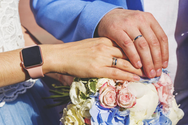 ブーケの結婚指輪と新婚夫婦の手。新郎新婦 - 写真・画像