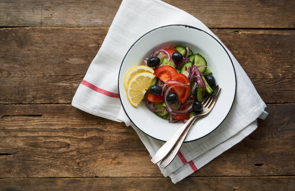 Salad of tomatoes, cucumbers, olives and red onions in a bowl                         - Photo, Image