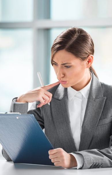 Front view of business woman looking over papers on clipboard at - Фото, зображення
