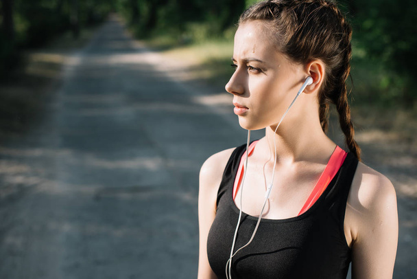 красивая спортивная женщина слушает музыку с наушниками
 - Фото, изображение