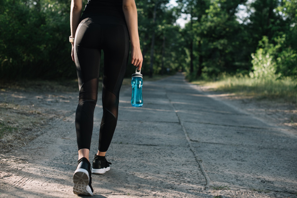 vágott képe sportoló, a sport-palack víz utat gyalog - Fotó, kép