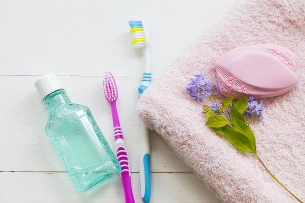 Diş macunu ve diş fırçası vücut cilt bakımı için bitkisel ve banyo havlusu gelen sabun ile sağlıklı bakım ağız boşluğu için arka plan beyaz ahşap banyo hazırlamak - Fotoğraf, Görsel