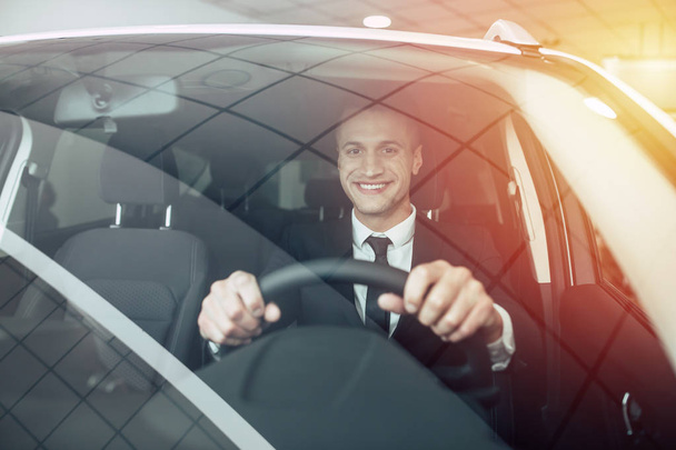 Happy businessman in suit driving car - Foto, afbeelding